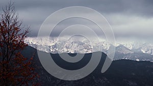 Time lapse of clouds floating over snow capped mountains