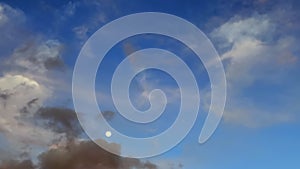 Time lapse of clouds and moon in the sky on sunny day