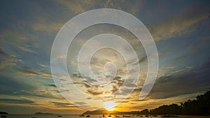 ..time lapse clouds moving in yellow sky in sunrise moving slowly above islands at Rawai beach Phuket.