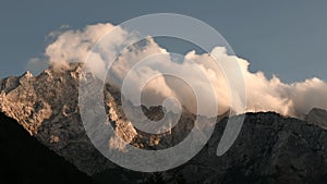 Time lapse clouds over mountain peak