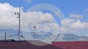 time lapse of clouds with roofs of houses and electric poles