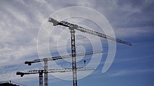 Time lapse at the construction site of the new district. 3 cranes at a construction site are moving construction work