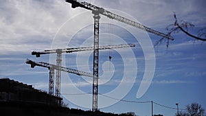 Time lapse at the construction site of the new district. 3 cranes at a construction site are moving construction work