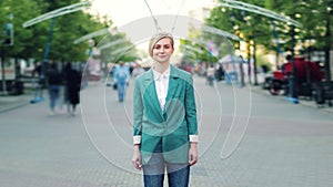 Time lapse of cute blond lady standing in the street among crowd of people