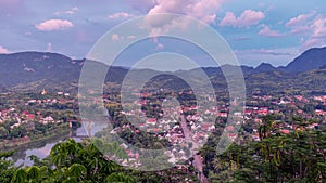 Time lapse day to night view of world heritage city of luangprabang with mountain on background