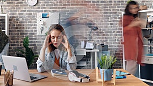 Time-lapse of depressed girl employee sufffering from headache in office