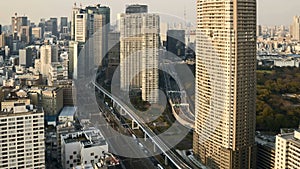 Time lapse of downtown Tokyo city skyline with motion blur car and fast train movement. Pan left