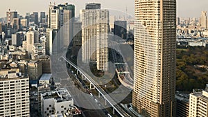 Time lapse of downtown Tokyo city skyline with motion blur car and fast train movement. Pan right