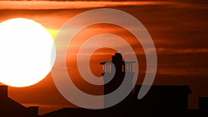 Time lapse - Extreme close up of the sun setting with dramatic clouds at sunset