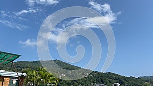 time lapse Fast moving clouds against a nice blue sky with Palm Tree and swaying in the wind Patong Phuket Thailand