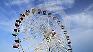 Time-lapse of Ferris Wheel at amusement park with blue sky background