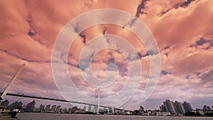 Time lapse of flying sunset glow cloud,shipping on river,across the sea bridge.