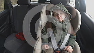 Time lapse. Little boy in the backseat of a car. The car is going on a bad road. Travel with baby. Sleeping kid with a