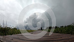 Time lapse motion The wooden bridge on the rice fields That sway in the wind and the clouds move fast on the sky