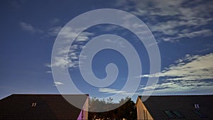 Time-lapse of the night starry sky with flying clouds