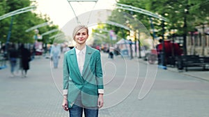 Time lapse portrait of serious young woman standing in city street among crowd