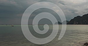 Time lapse of rain clouds over beach and sea landscape with boats. Tropical storm in ocean.