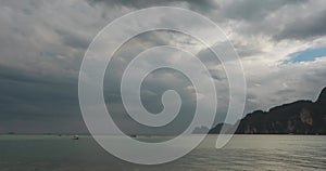 Time lapse of rain clouds over beach and sea landscape with boats. Tropical storm in ocean.