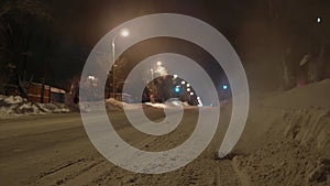 Time-lapse shooting Russian winter road in the evening. Steam comes out of the sewer grate on the road