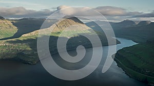 Time lapse of sunset in the fjord at viewpoint Hvithamar with moving clouds over mountains, Funningur Faroe Islands