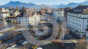 Time Lapse, traffic in the European town on sunny winter day. Swiss town with mountains on the background. River Reuss. Lucerne,