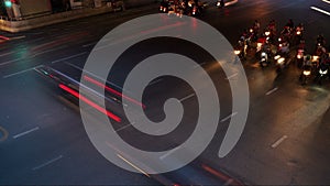 Time lapse of traffic long exposure light trails across road junction during rush hour, from evening to dusk, unrecognizable faces
