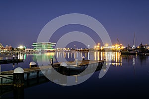 Valencia harbor, port night lights reflection in water, buildings