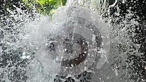 Time lapse video of man practicing martial arts under waterfall in wild nature. Male person boxing under water stream in