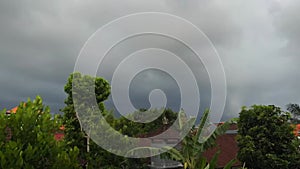 Time lapse video of rain clouds flying with wind above beautiful green tropical village in countryside. Rainy season in
