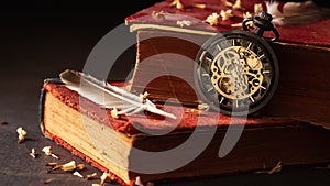 Time lapse winding pocket watch on old books with feathers and dried flower petals