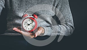 Time and life concepts with young man holding alarm clock and sitting on sofa.Motivation images