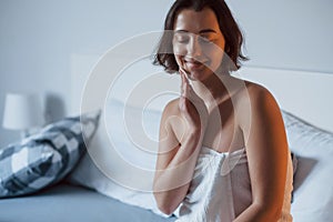 Time for a make up. Woman sits on the bed and use cosmetics to clean her skin