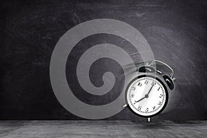 Retro black alarm clock alerting at seven o`clock on chalkboard background. photo
