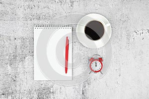 Time management concept. To-do list: red alarm clock, pencil and notebook