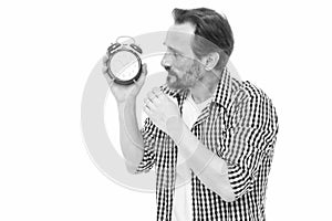 Time is marching on. Senior man looking at clock. Bearded man with mechanical clock in hand. Mature timekeeper with photo