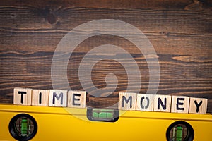 Time and Money balance concept. Spirit level on a wooden background