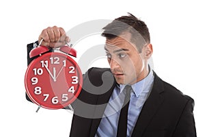 Time is money : businessman holding up red alarm clock isolated