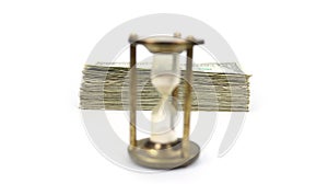 Time Is Money with Metal Sand Timer Blurred, Stack Of Money In Focus