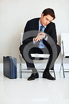 Time is money-Businessman checking the time. Time is money - Portrait of a young businessman checking the time on wrist