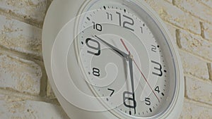 Time nine hours thirty minutes. Timelapse. Round white clock hanging on brick wall.