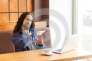 Time out! Portrait of serious handsome young adult man freelancer in casual style sitting in cafe and talking with his friend in