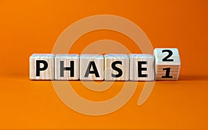 Time for Phase 2. Turntd a cube and changed the word `Phase 1` to `Phase 2`. Beautiful orange background. Business concept. Co photo