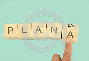 Time for Plan B. Hand is turning a cube and changes the word `Plan A` to `Plan B`.. Business concept. Copy space.Beautiful blue ba