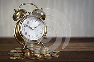 Time is precious concept.golden alarm clock on coins