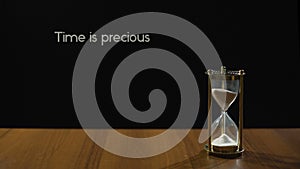 Time is precious, popular expression about value of life, sandglass on table