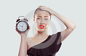 Time pressure. Closeup portrait woman stressed employee holding clock looking at you camera anxiously running out of time isolated
