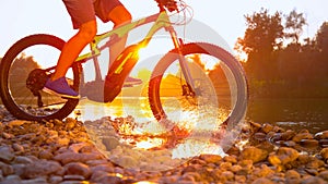 TIME REMAP: Cool shot of mountain biker riding across a river on golden morning.