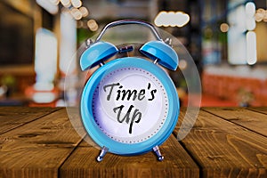 Time`s up text on Alarm Clock on wooden table.