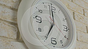 Time seven hour. Timelapse. Round white clock hanging on brick wall.