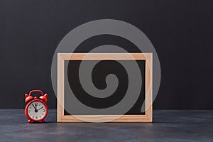 Time for shopping. Black friday. Big sale backdrop. Blank chalkboard and red alarm-clock on dark background, copy space